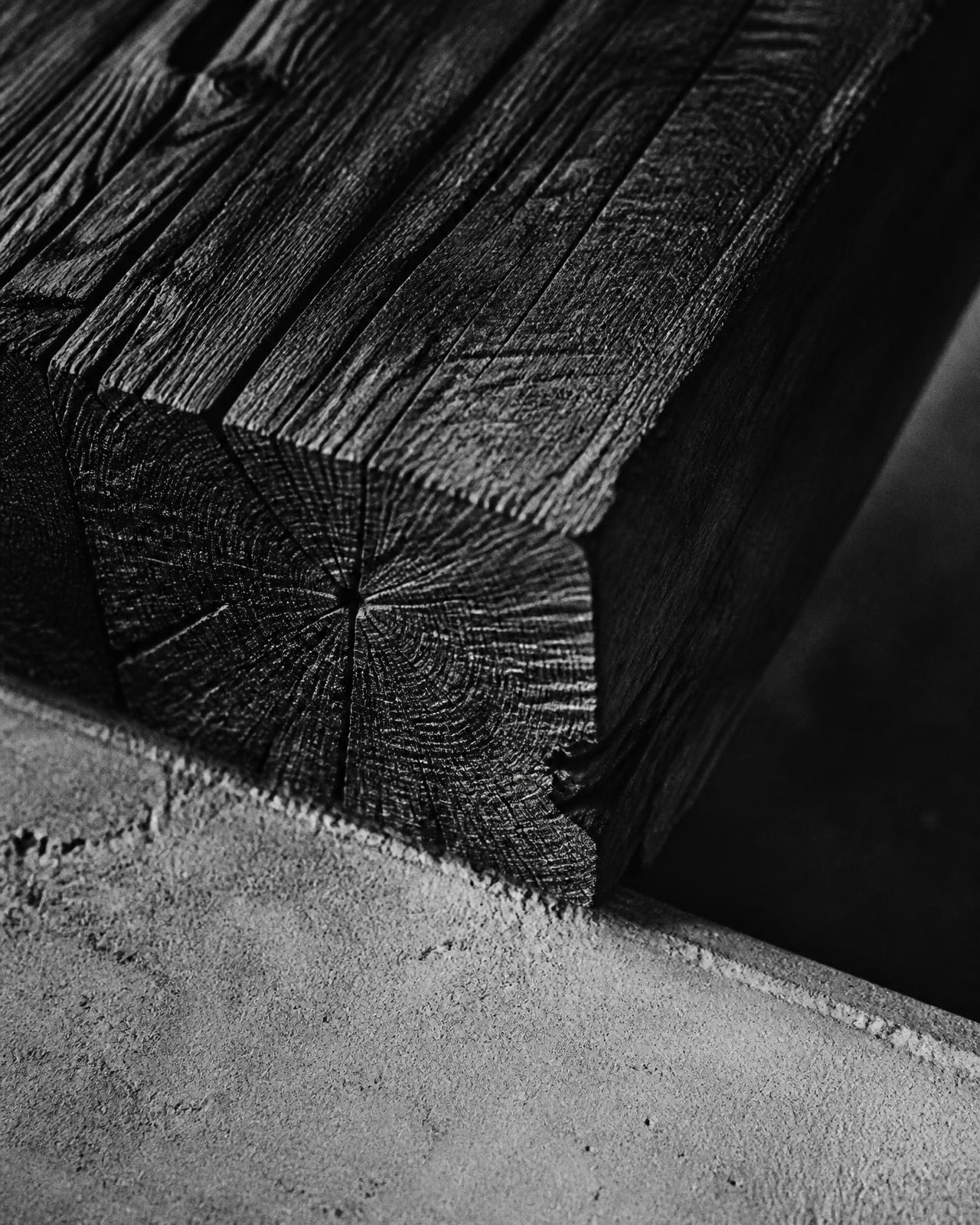 Close-up of a dark oak slab meeting concrete